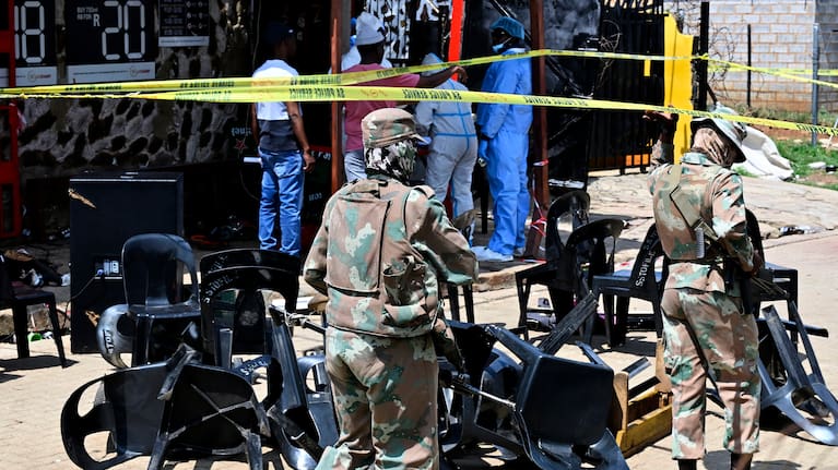 Forensic officers and the army members are seen at scene of a mass shooting on Saturday night when suspects opened fire at a bar in Wedela township, southwest of Johannesburg.