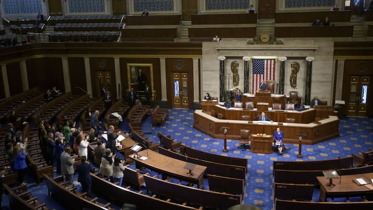House Minority Leader Hakeem Jeffries, D-N.Y., left, speaks in the House chamber as House Democrats stand to applaud him.
