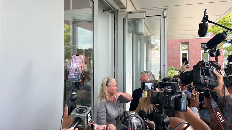 In this photo taken with a smartphone Dawn Light is questioned by reporters as she leaves her arraignment where she was charged with intimidation.