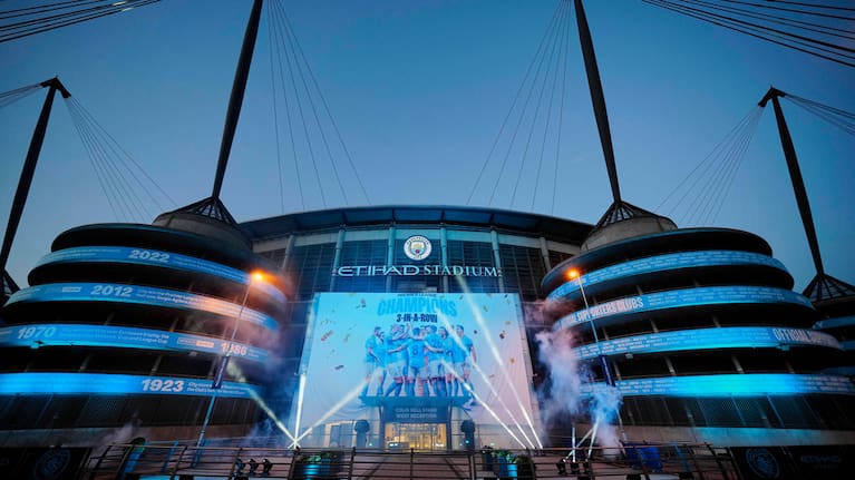 A banner celebrating their title win is illuminated outside Manchester City's Etihad stadium in Manchester, England, Saturday, May 20, 2023