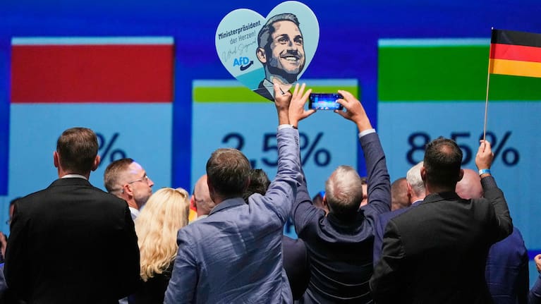 Party members celebrate with a sign of AfD top candidate Ulrich Siegmund after the first results at an election party.