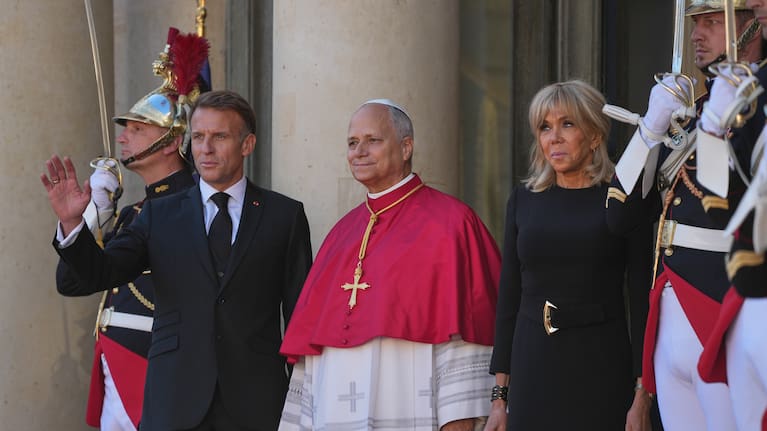 Pope Leo XIV (centre) stands in between Emmanuel Macron and his wife Brigitte.