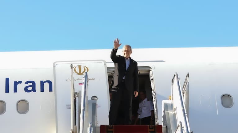 President Masoud Pezeshkian waves to media and officials as he boards his plane while leaving Mehrabad airport for New York.