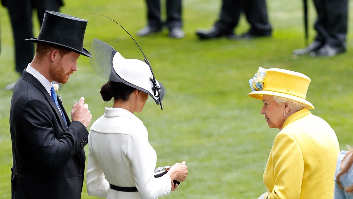 Prince Harry, Meghan Markle, and Queen Elizabeth II standing together at Ascot Racecourse