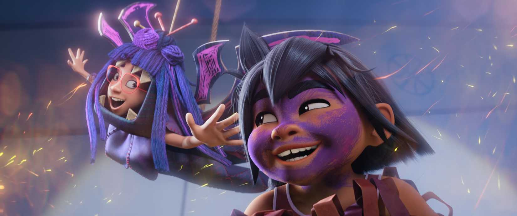 Two Filipino children, Raissa and Jo, yelling excitedly on stage at a school performance in the animated movie Forgotten Island. Raissa is swinging from the ceiling in the background, wearing purple wings and a purple string wig. Jo is in the foreground, face smeared with purple makeup.