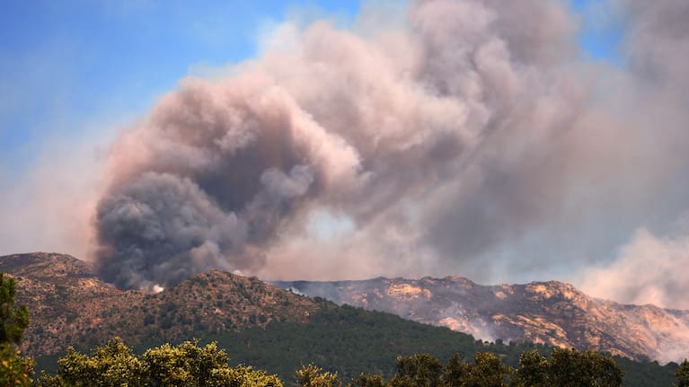 Smoke and flames rise as a wildfire advances near La Adrada, Ávila province, Spain, Friday, July 24, 2026.