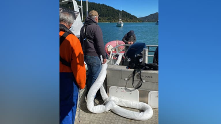 The harbourmaster team deploys oil-absorbent booms to capture any potential oil spill.