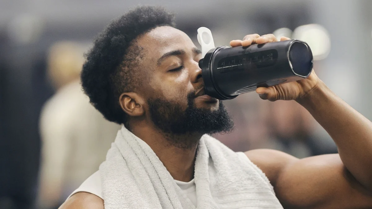 male weight lifting drinking from a bottle