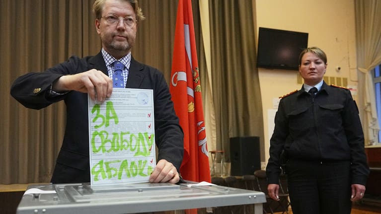 Yabloko party leader Nikolai Rybakov casts a ballot with a writing in Russian reading "For freedom" during the parliamentary election in St. Petersburg, Russia, Sunday, Sept. 20, 2026.