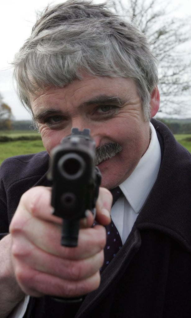 Minister for Defence, Willie O'Dea trys out an automatic pistol with members of the Army Rangers Wing during an excercise at the Curragh Camp