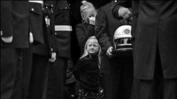 Daughter of fire fighter Brian Murray, who died in a factory fire in Bray, as his coffin is removed from the church.