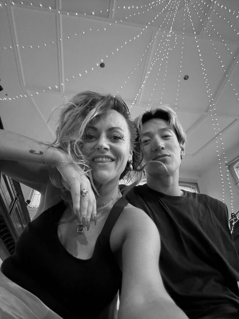 two people smiling with decorative lights on the ceiling above them. two people smiling with decorative lights on the ceiling above them.