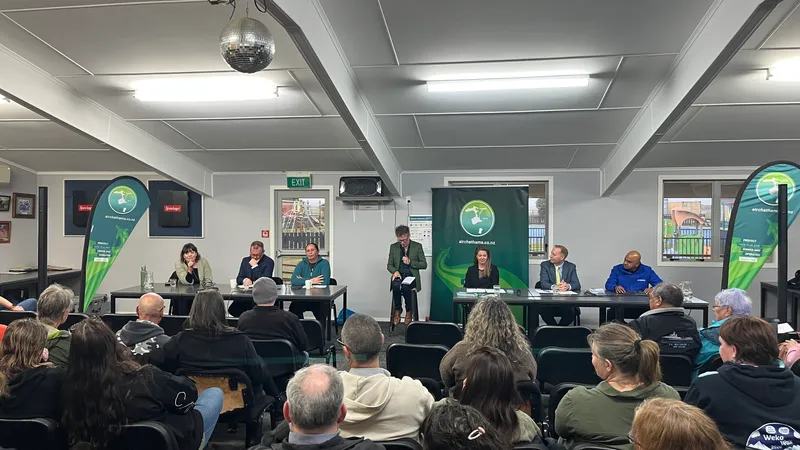 a brightly lit community room with two tables where six political candidates sit, with a moderator on a stool in the middle. a small audience watches them