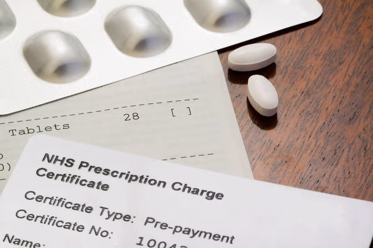 "Prescription Drugs in the UK can be made significantly more affordable with an annual prescription pre-payment for the National Health Service, NHS Prescription Charge Certificate. This entitles the bearer unlimited prescription drugs for a year, for the set fee. The entitlement card is shown here with a UK prescription and a foil blister pack and tablets.."