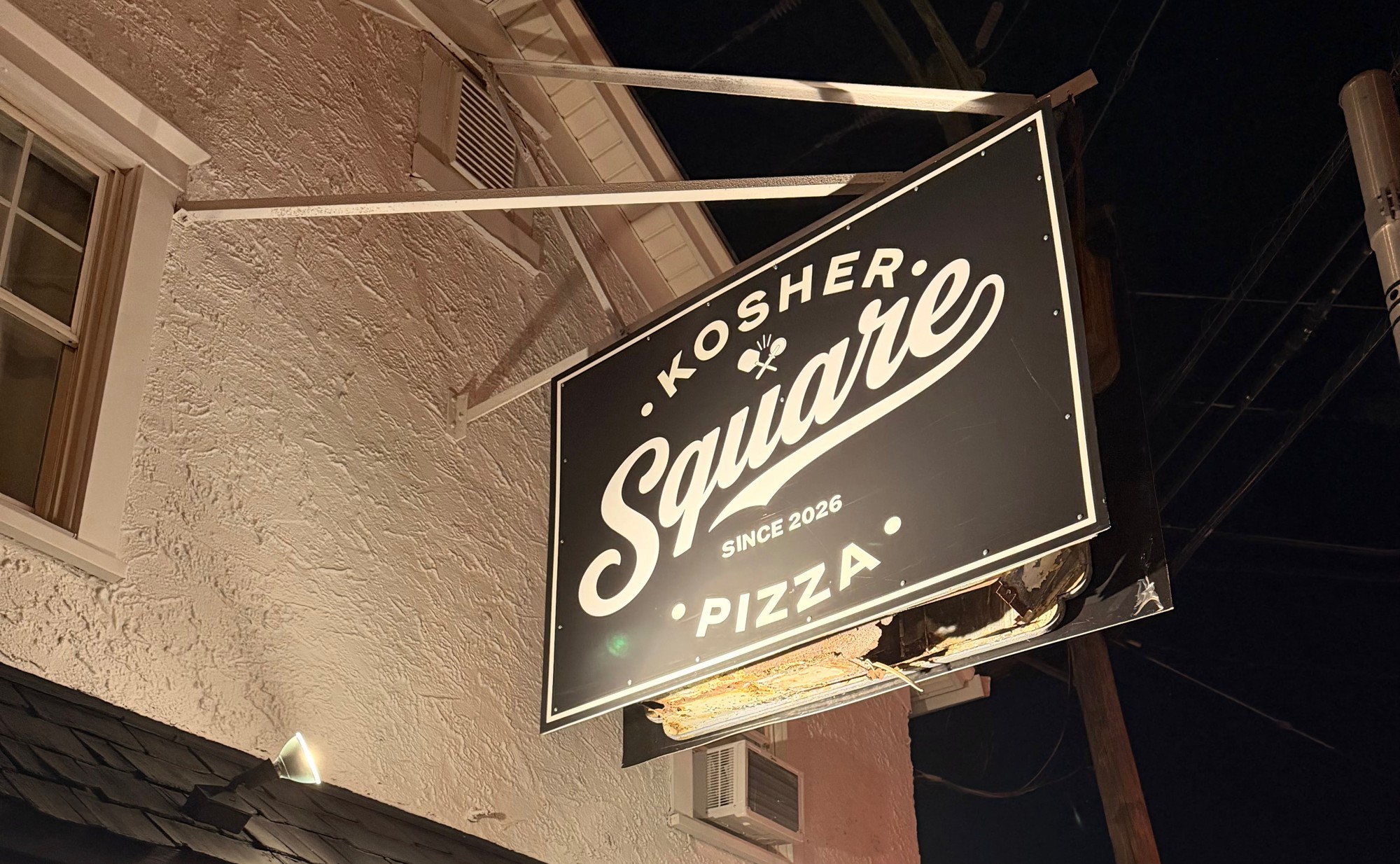 Kosher Square Pizza's hanging storefront sign in Oakhurst, NJ