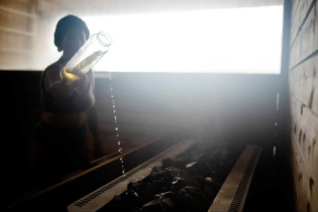 Sauna master Hilde Karlsen pours liquid on hot rocks during a sauna ritual at Sukkerbiten in Oslo, Norway, Sept. 25, 2026.