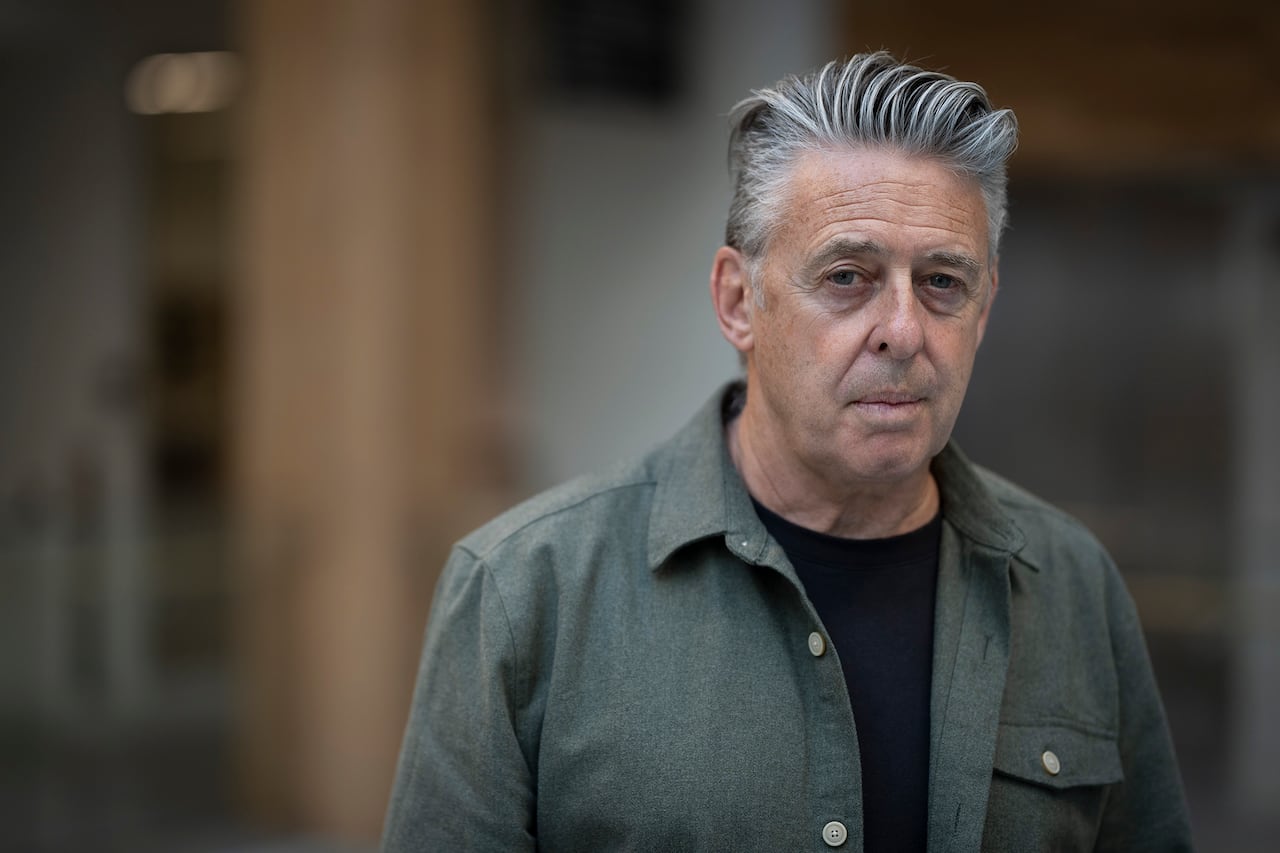 A man with grey hair in a button-down shirt.