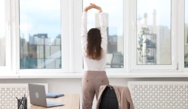 Young businesswoman doing stretching exercise in office, back view