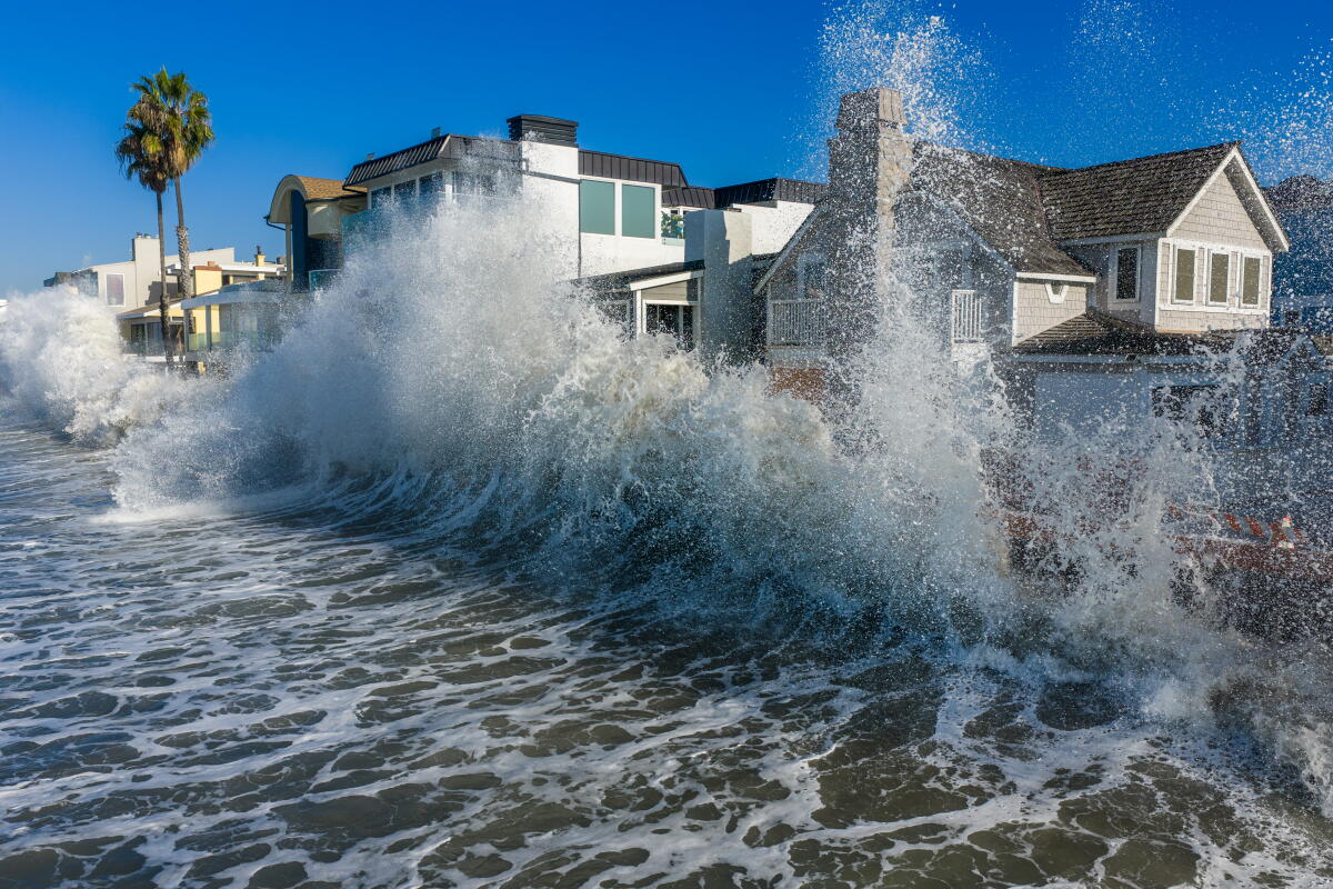 A wave crashes against seawall boards and damaged beachfront homes along the Long Beach peninsula.