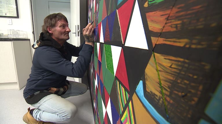 James Walker paints a mural at Te Whare o Tapatahi.