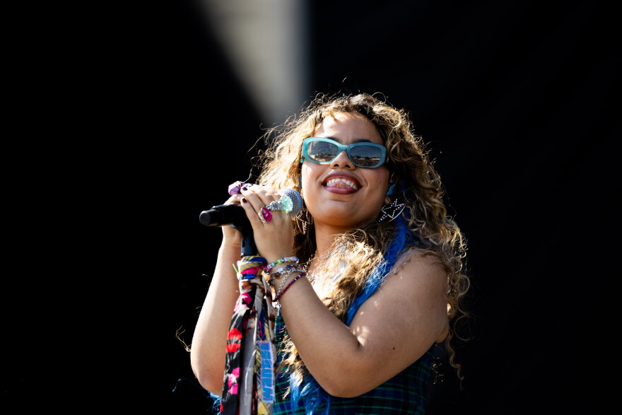 A woman sticks her tongue out as she performs on a stage.