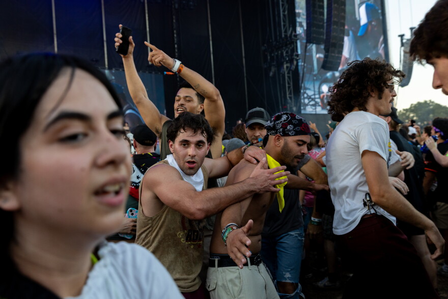 People push each other in a mosh pit at a concert.