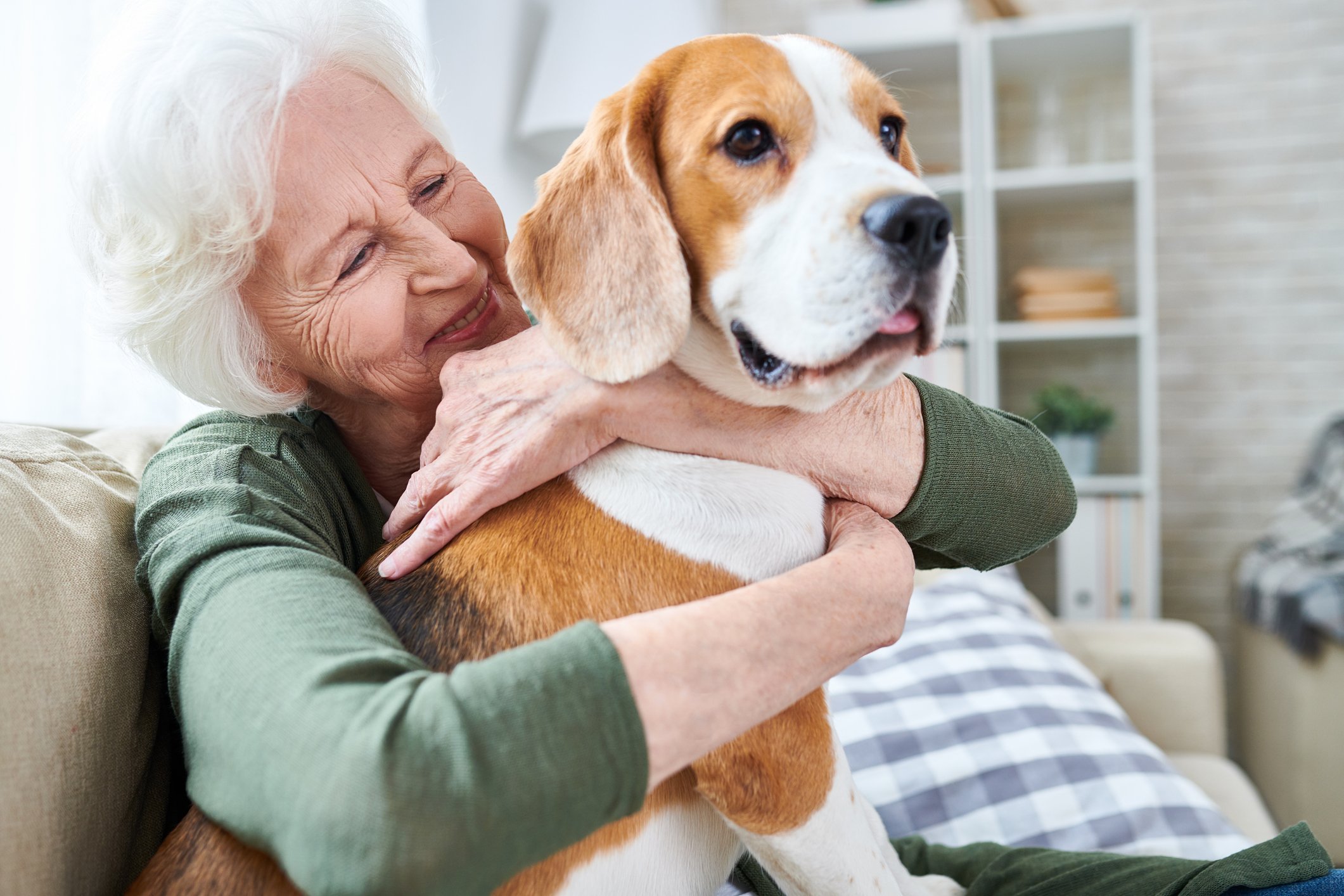 Smiling person holding a dog.