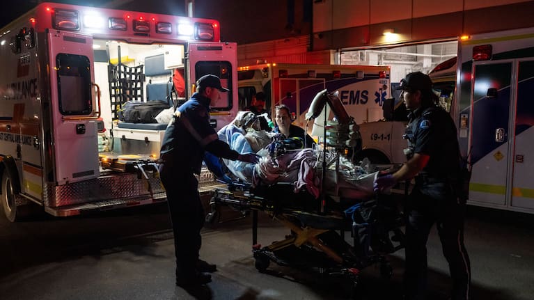 Paramedics load an injured person into an ambulance at the Wainwright Health center after a fire at Canadian Forces Base Wainwright