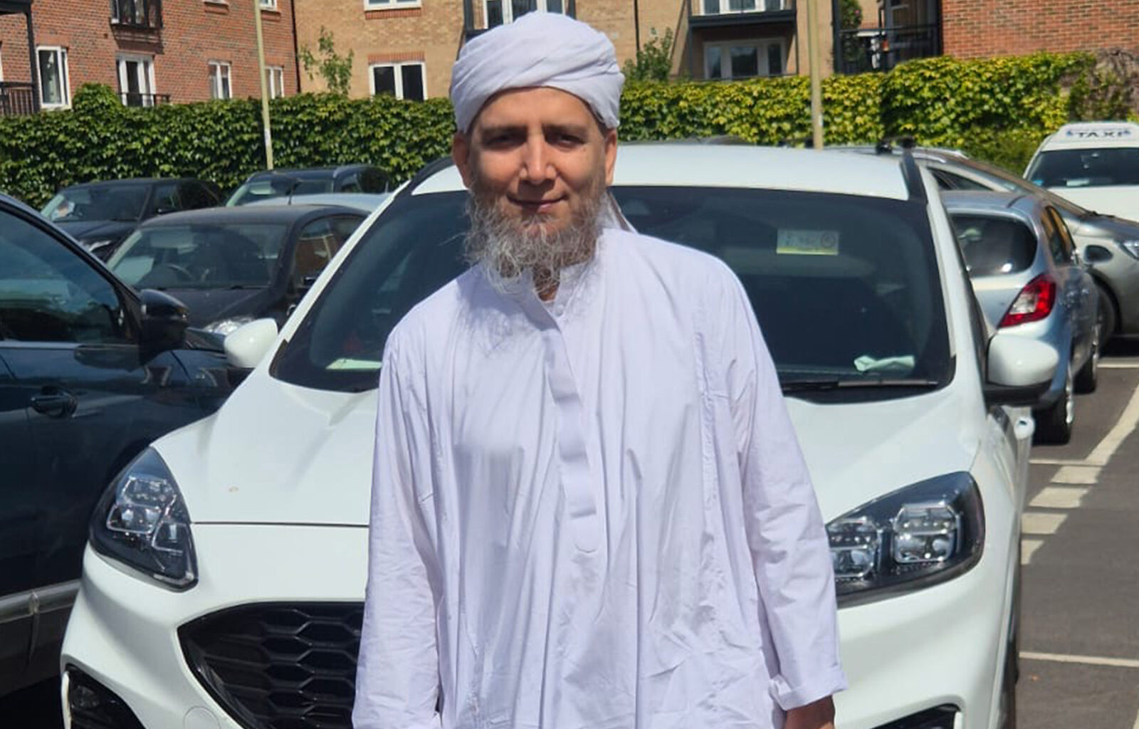 A man smiling wearing white