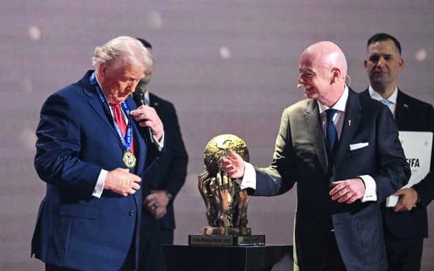 US President Donald Trump reacts as he receives the FIFA Peace Prize from Italian Fifa President Gianni Infantino during the draw for the 2026 FIFA Football World Cup taking place in the US, Canada and Mexico, at the Kennedy Center, in Washington, DC, on December 5, 2025. (Photo by SAUL LOEB / AFP)