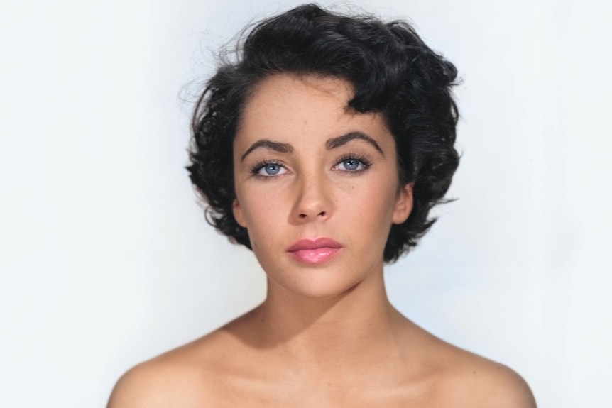 Close up head shot of Elizabeth Taylor on a white backdrop