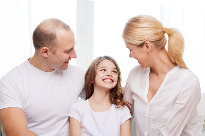 Happy young family sitting together, illustrating potential patients in a medical context.