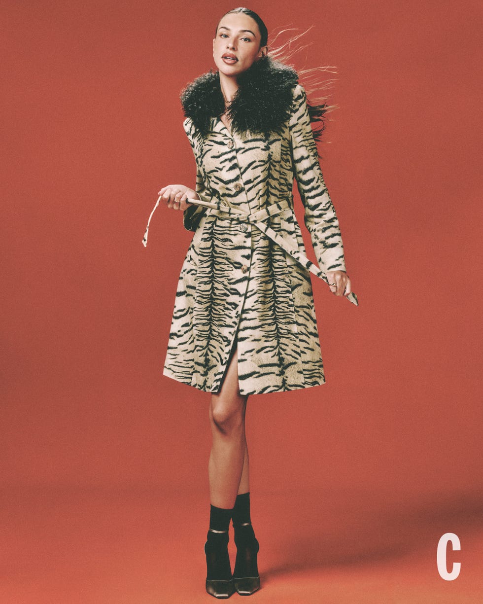 person in a tiger striped coat with fur collar, red background. person in a tiger striped coat with fur collar, red background.