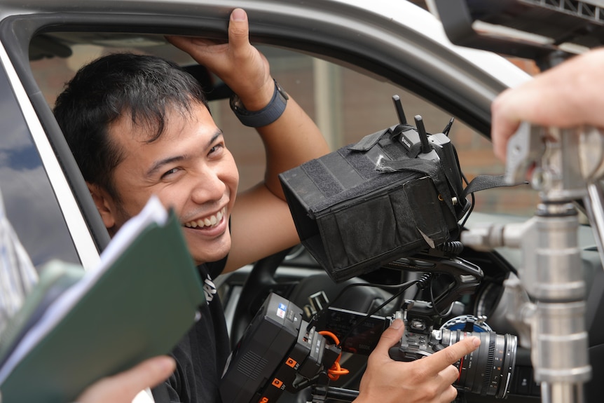 indonesian filmmaker with a camera in a car