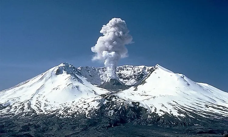 Snow-covered Mount St. Helens releasing a steam plume in 1982.