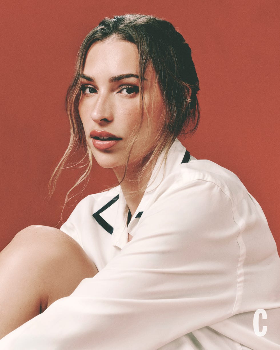 person in white shirt against a warm red background. person in white shirt against a warm red background.