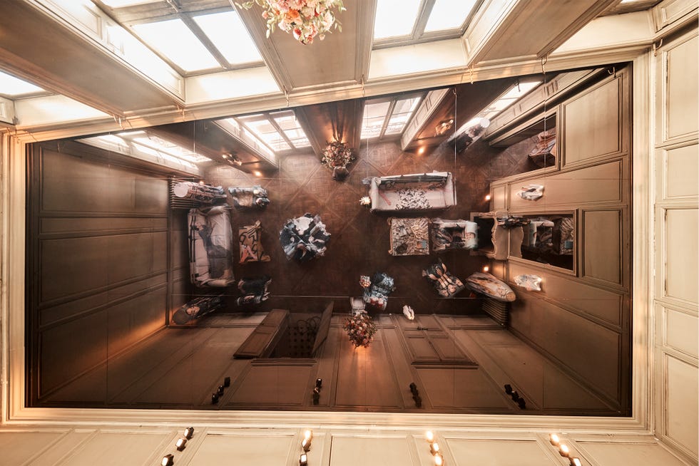 Aerial view of a stylish living room with patterned furniture and a chandelier overhead.