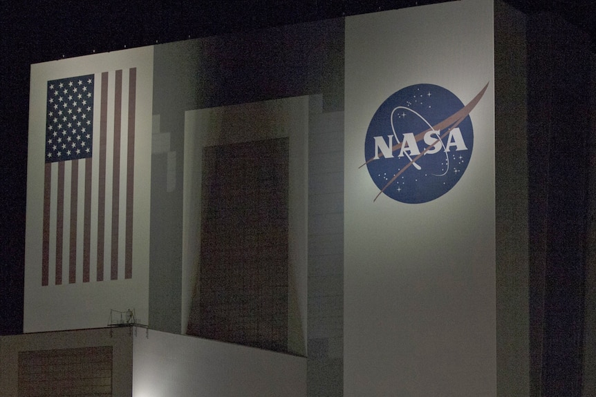 the side of a nasa building with the logo and the american flag on the walls