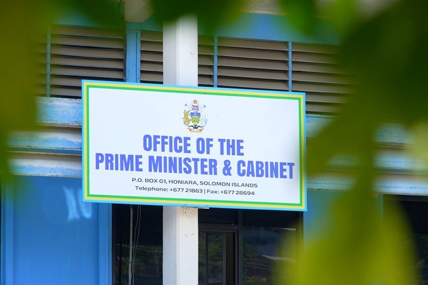 A sign on a building says "Office of The Prime Minister and Cabinet".