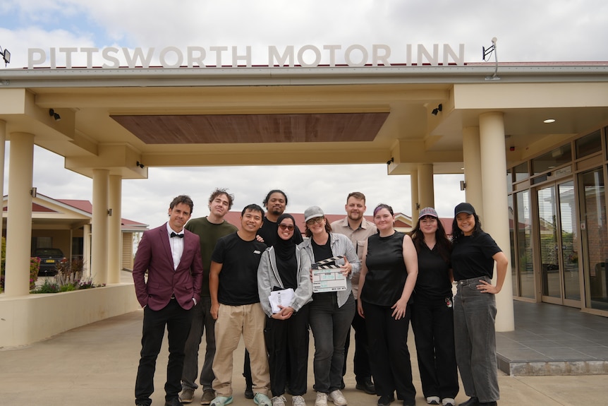 a group photo of the filmmakers standing outside the pittsworth motor inn