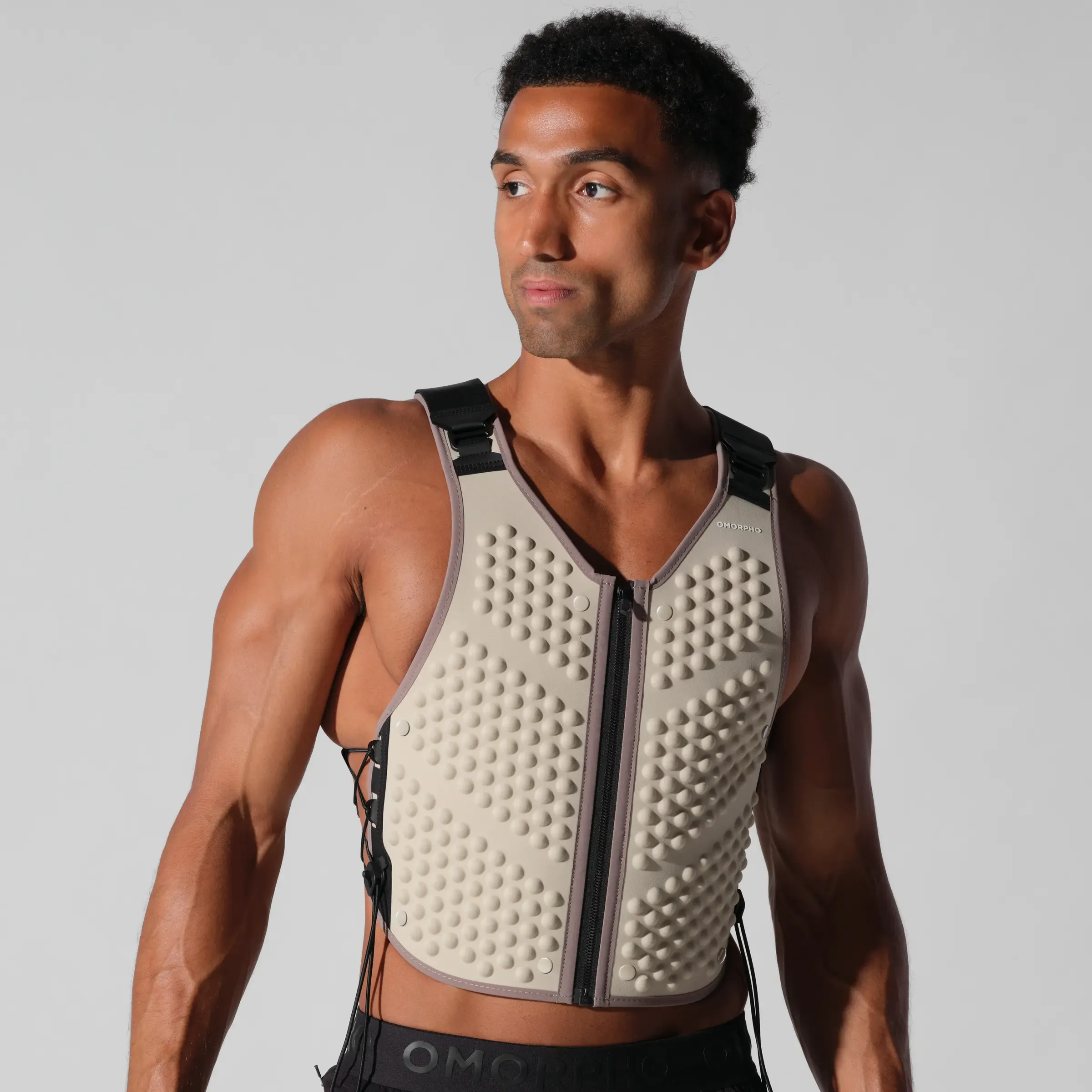 A man wearing a weighted vest against a plain background