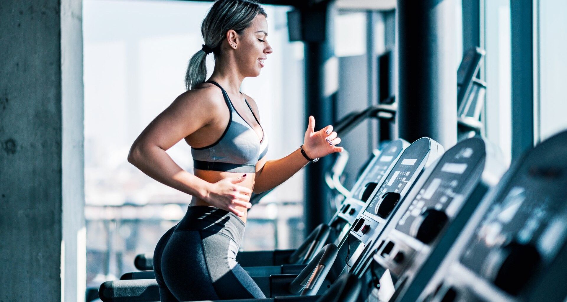 Woman running on a treadmill during treadmill workout, left arm forward right arm back
