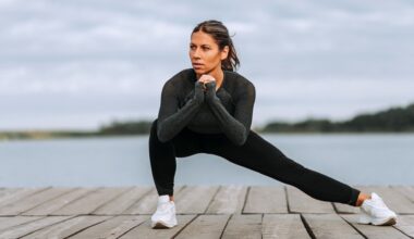 Woman performing a Cossack squat with right knee bent and left knee extended with backdrop of a river