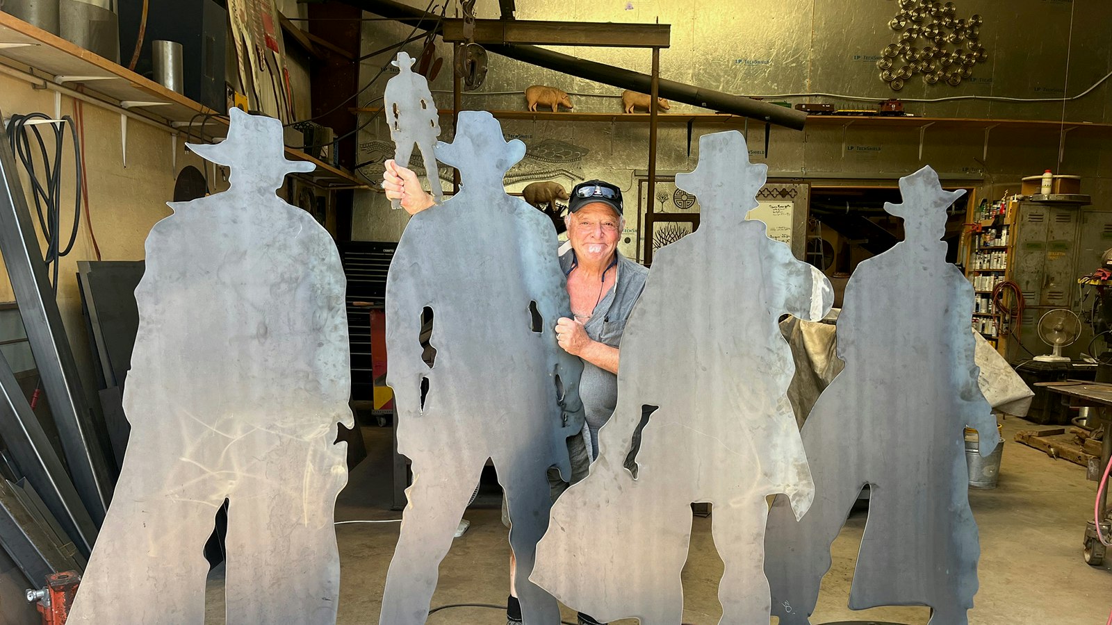 Artist Thom Ross with four Western cutouts he made.