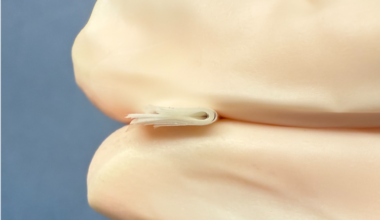 Researchers at Penn Engineering demonstrate the flexibility and durability of stacked Mylar insulating layers, shown held between gloved fingers for scale. (Credit: Bargatin Lab)
