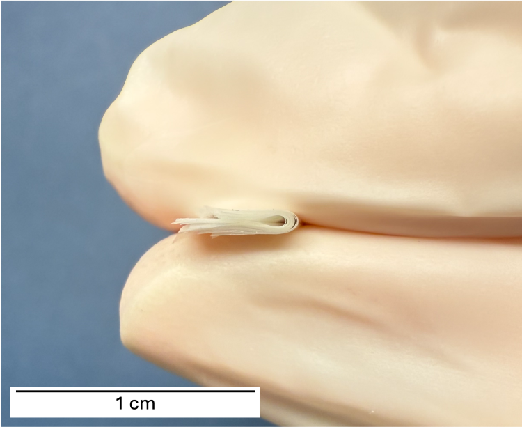 Researchers at Penn Engineering demonstrate the flexibility and durability of stacked Mylar insulating layers, shown held between gloved fingers for scale. (Credit: Bargatin Lab)