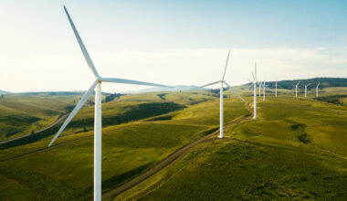 Wind turbines tower above the earth in a rural setting, drawing renewable energy as they spin. Sustainable energy and green technology that considers the environment. Shot in Washington state, USA.