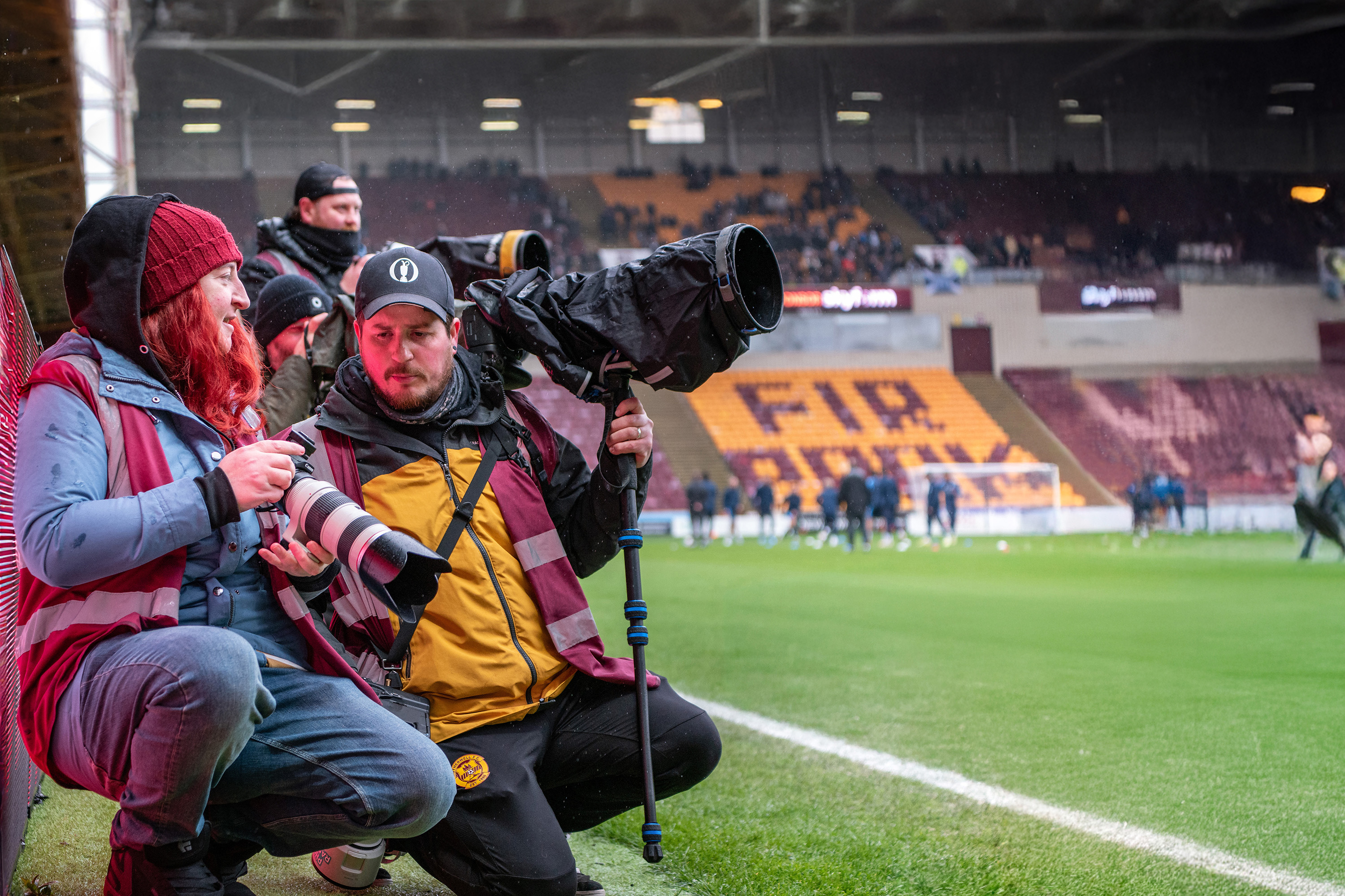 Photo of the pitchside at the Scottish Premiership clash between Motherwell and Falkirk, April 4, 2026, showing club photographer Raymond Davies and his mentee, student Chantelle Cook.