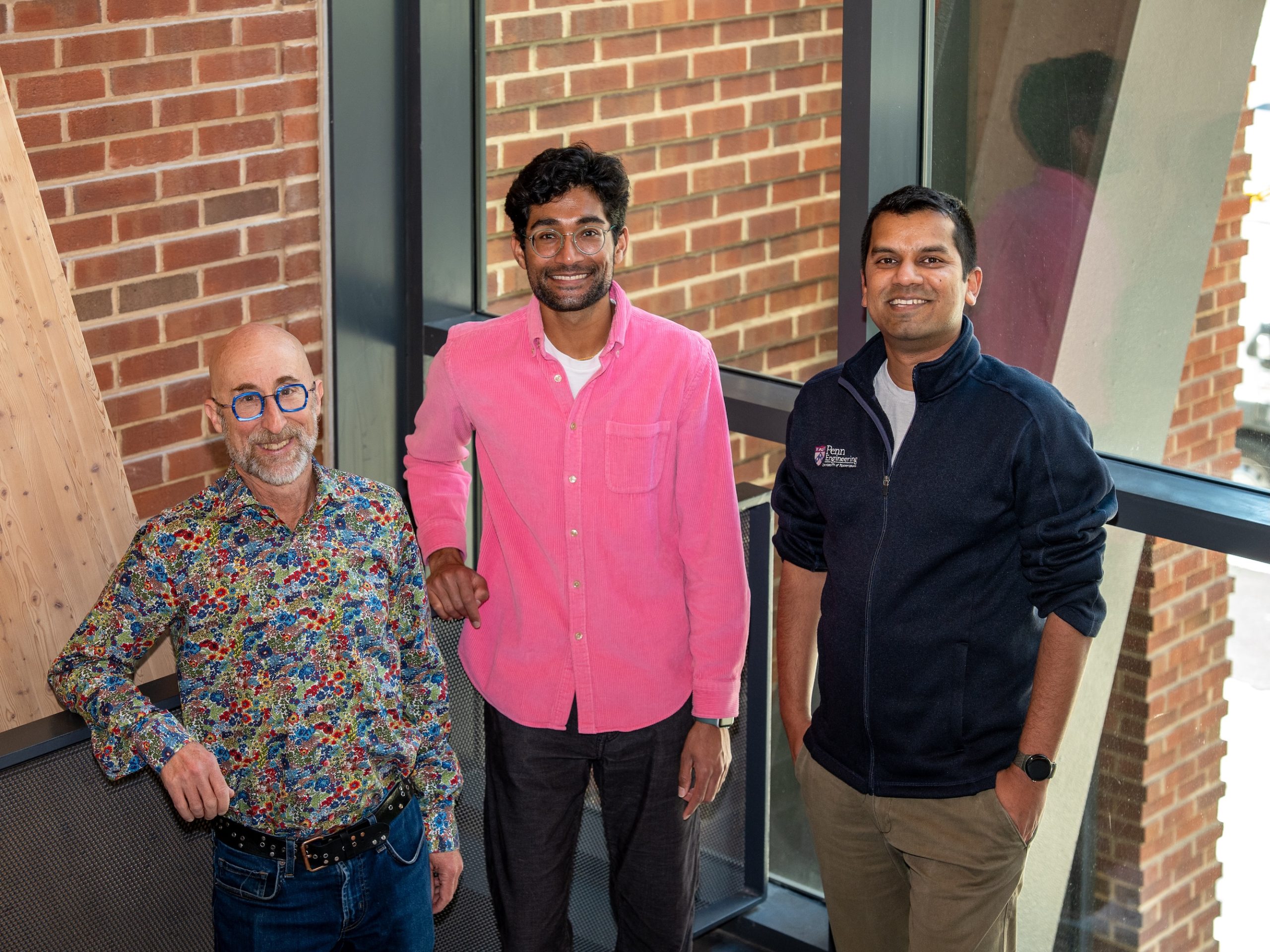 Three researchers stand side by side, smiling at the camera.