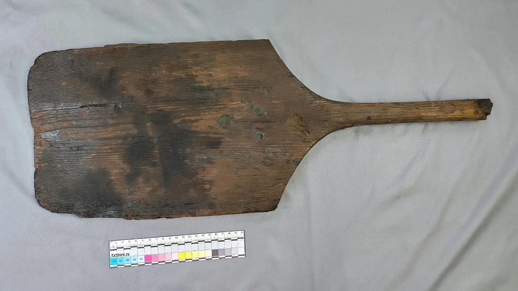 a flat, rectangular wooden paddle with a broken-off handle